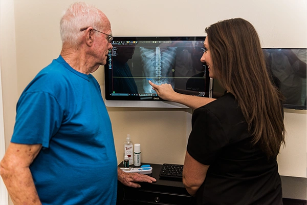 Chiropractor Carrollton TX Emilee Quiroz Consulting With Patient