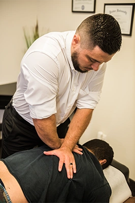 Chiropractor Richardson TX Pierre Quiroz Adjusting Patients Back